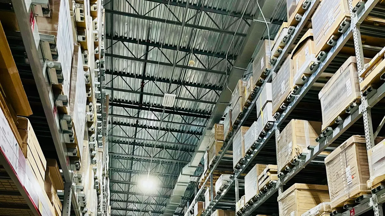 Warehouse aisle with shelves of stocked boxes - barcode labels and stock transfer between retail outlets