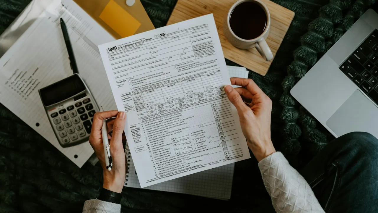 Hands filling in a tax form next to a calculator - GST billing and tax reporting for a retail shop