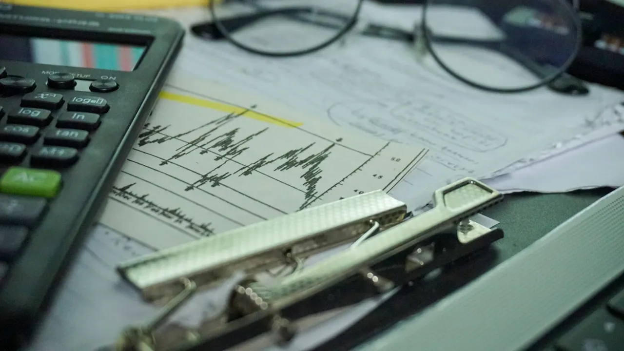 Calculator, charts and papers on a desk - profit and loss and balance sheet reports for a retail store